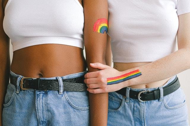 Two people with rainbows on their arms